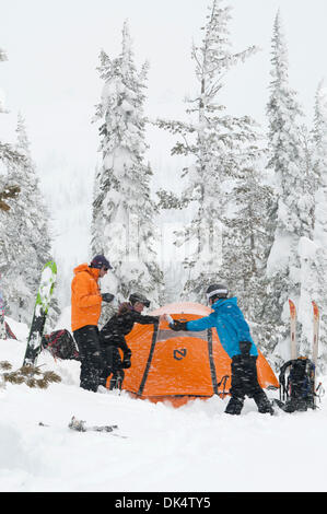 27. Februar 2011 - Missoula, Montana, USA - Sarah Ogburn (schwarze Jacke), Matt Cornette (blaue Jacke) und Pete Barrett (orange Jacke) genießen einen Drink und die wehenden Schnee... Skifahrer-Camp und Ski im Hinterland von den Bitterroot Bergen von Montana. (Kredit-Bild: © Jed Conklin/ZUMAPRESS.com) Stockfoto