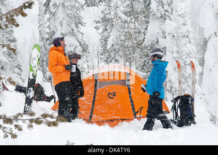 27. Februar 2011 - Missoula, Montana, USA - Sarah Ogburn (schwarze Jacke), Matt Cornette (blaue Jacke) und Pete Barrett (orange Jacke) genießen einen Drink und die wehenden Schnee... Skifahrer-Camp und Ski im Hinterland von den Bitterroot Bergen von Montana. (Kredit-Bild: © Jed Conklin/ZUMAPRESS.com) Stockfoto