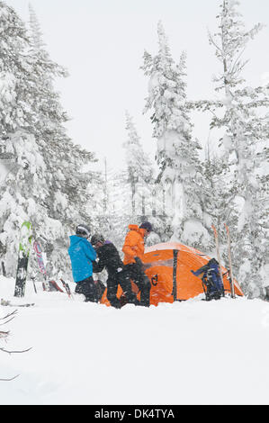 27. Februar 2011 - Missoula, Montana, USA - Sarah Ogburn (schwarze Jacke), Matt Cornette (blaue Jacke) und Pete Barrett (orange Jacke) genießen einen Drink und die wehenden Schnee... Skifahrer-Camp und Ski im Hinterland von den Bitterroot Bergen von Montana. (Kredit-Bild: © Jed Conklin/ZUMAPRESS.com) Stockfoto