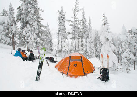 27. Februar 2011 - Missoula, Montana, USA - Sarah Ogburn (schwarze Jacke), Matt Cornette (blaue Jacke) und Pete Barrett (orange Jacke) haben einen Drink in ihrem Lager in einer Küche, die sie aus dem Schnee gegraben... Skifahrer-Camp und Ski im Hinterland von den Bitterroot Bergen von Montana. (Kredit-Bild: © Jed Conklin/ZUMAPRESS.com) Stockfoto