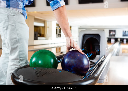 Menschenhand Abholung Bowling-Kugel von Rack Stockfoto