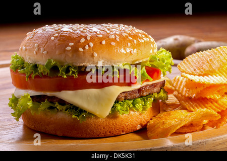Burger mit Pommes Frites auf Holzplatten und schwarzen Hintergrund. Stockfoto