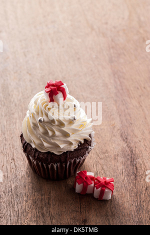Christmas Cupcake dekoriert mit Geschenk-Box auf Holztisch Stockfoto