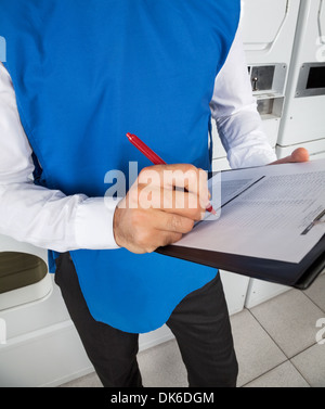 Männliche Helfer Check-Liste In der Wäscherei Stockfoto