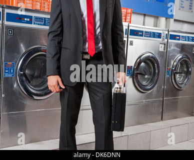 Geschäftsmann mit Koffer In Wäsche Stockfoto