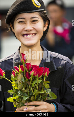 Bangkok, Thailand. 3. Dezember 2013. Frauen Thai Polizisten Line-up mit Rosen, Anti-Regierungs-Demonstranten in Bangkok zu präsentieren. Tausende von Anti-Regierungs-Demonstranten trat die Regierungsbüros im Dusit-Bezirk von Bangkok Dienstag nach Polizei mit Tränengas und Wasserwerfer auf die Demonstranten gestoppt. Demonstranten zogen durch das Viertel Thai Fahnen schwenkten und skandierten "lang lebe den König!'' Suthep Thaugsuban, Führer der Protestbewegung, nannte es ein Teilsieg aber geschworen, seinen Kampf zu stürzen die Regierung von Yingluck Shinawatra fortzusetzen. (Kredit-Bild: © Stockfoto