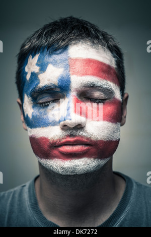 Porträt des Mannes mit USA-Flagge auf seinem Gesicht gemalt und schloss die Augen. Stockfoto