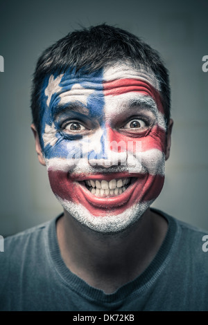 Porträt von lustigen toothy Lächeln Mann mit US-Flagge auf Gesicht gemalt. Stockfoto