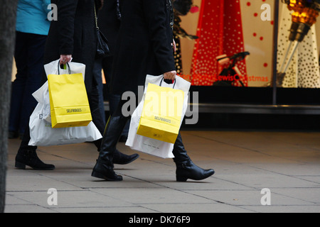 Teil von zwei Menschen, Selfridges und andere Einkaufstaschen auf der Oxford Street in London England Stockfoto