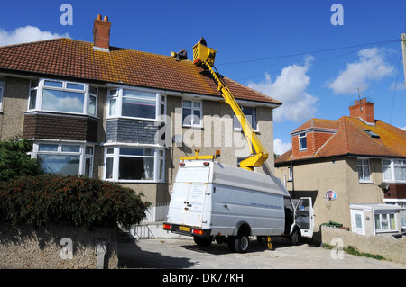 Dach-Reparaturen, Arbeiter, Reparatur Dach mit "Hubarbeitsbühnen" in Großbritannien, UK Stockfoto