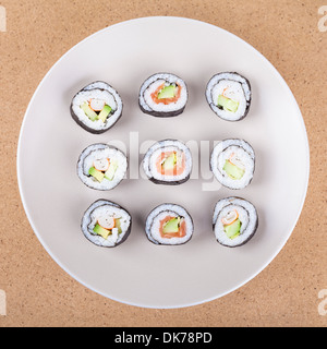 Teller Sushi Rollen über hölzerne Hintergrund. Stockfoto