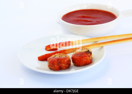 Zwieback mit Sesam, Brot-Sticks und roter Soße auf grauem Hintergrund isoliert. Stockfoto