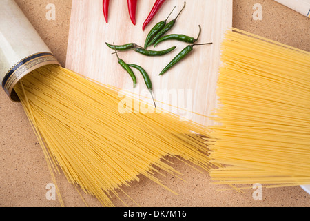 Getrocknete Teigwaren und Chilischoten auf Holztisch. Stockfoto