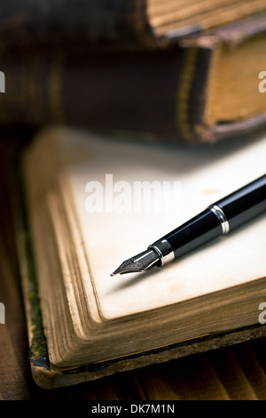 Öffnen Sie altes Buch mit Füllfederhalter auf Holztisch Stockfoto