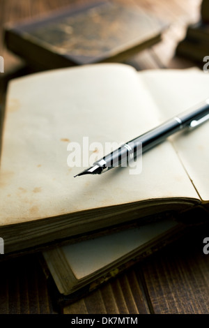 Öffnen Sie altes Buch mit Füllfederhalter auf Holztisch Stockfoto