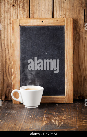 Kaffeetasse und Vintage Schiefer Tafel auf hölzernen Hintergrund Stockfoto