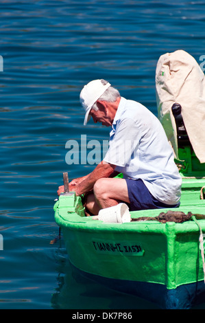 Ein griechischer Fischer arbeitet auf seinem Boot Stockfoto