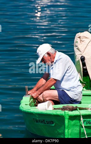 Ein griechischer Fischer arbeitet auf seinem Boot Stockfoto