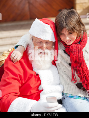 Junge und Santa Claus mit Smartphone Stockfoto