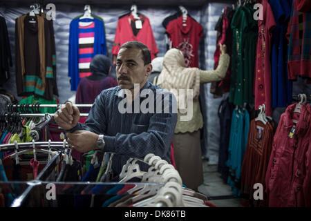 Kairo, Ägypten. 3. Dezember 2013.  Salesclerk Ali (R) ordnet Kleidung in einem Tuch-Shop in der Nähe von Tahrir-Platz. Ali arbeitet für den 21 Jahre alten Tuch Shop seit 6 Jahren er die Geschäft Turbulenzen während der inländischen politischen Veränderungen erlebt hat. Er räumt ein, dass der Shop-Betreiber Mohamed derzeit hat Mitarbeiter Gehalt aus seiner eigenen Tasche und Wirtschaft Zahlen seit 2011 stark betroffen ist. Der Laden hatte am 15:00 auf Dec.1 geschlossen werden, die die goldene Zeit zum Einkaufen genutzt. © Xinhua/Alamy Live-Nachrichten Stockfoto