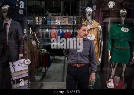 Kairo, Ägypten. 3. Dezember 2013.  Salesclerk Ali (R) ordnet Kleidung in einem Tuch-Shop in der Nähe von Tahrir-Platz. Ali arbeitet für den 21 Jahre alten Tuch Shop seit 6 Jahren er die Geschäft Turbulenzen während der inländischen politischen Veränderungen erlebt hat. Er räumt ein, dass der Shop-Betreiber Mohamed derzeit hat Mitarbeiter Gehalt aus seiner eigenen Tasche und Wirtschaft Zahlen seit 2011 stark betroffen ist. Der Laden hatte am 15:00 auf Dec.1 geschlossen werden, die die goldene Zeit zum Einkaufen genutzt. © Xinhua/Alamy Live-Nachrichten Stockfoto