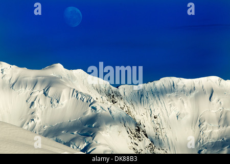 Antarktis, Port Lockroy, Mond setzt oben vergletscherte Gipfel des Berges Gipfel steigen entlang der antarktischen Halbinsel Stockfoto