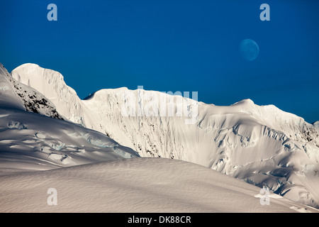 Antarktis, Port Lockroy, Mond setzt oben vergletscherte Gipfel des Berges Gipfel steigen entlang der antarktischen Halbinsel Stockfoto