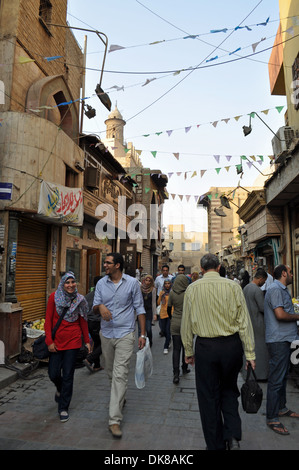 Ein entspanntes junges ägyptisches Paar ist unter der Menge, die eine schmale Straße im islamischen Viertel der Hauptstadt Kairo entlang geht. Stockfoto