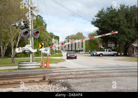 Bahnübergang Barriere in der geschlossenen Position mit trainieren sich nähernden DeLand, Florida USA Stockfoto