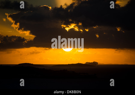 KARIBISCHES MEER – Ein dramatischer karibischer Sonnenuntergang färbt den Himmel in leuchtenden Orange- und Goldtönen. Stockfoto