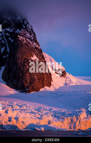 Antarktis, Petermann Island, Einstellung Mitternachtssonne Leuchten Berggipfel und Gletscher entlang Lemaire-Kanal Stockfoto