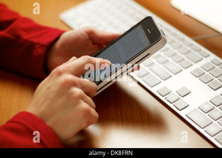 Weibliche Hände schreiben auf einem Touchscreen Smartphone arbeiten in ihrem Büro. Stockfoto