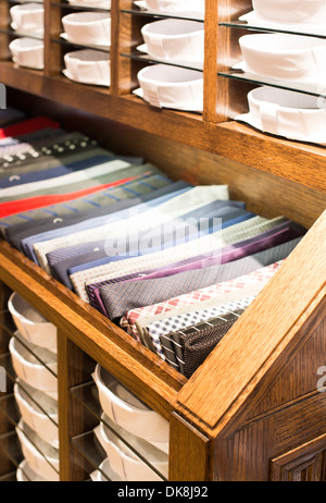 Krawatten, gestapelt auf einem Holzregal in einem Geschäft Stockfoto