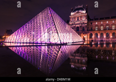 Nachtaufnahme vom Eingang Pyramide des Louvre, Paris. Spiegelbild im Teich Stockfoto