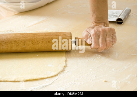 Hand arbeitet mit Nudelholz in Küche Stockfoto