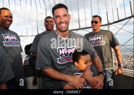 27. Juli 2011 - Manhattan, New York, USA - CC SABATHIA, MIKE HARKEY und FREDDY GARCIA zusehen, wie JORGE POSADA hat einen lachen mit Student Frantz Bleus auf der 86. Etage Sternwarte. New York Yankees-Spieler und Trainer zusammen mit einer Gruppe von haitianischen Kindern aus Ss. Joachim und Anna Schule in Queens (die Flüchtlinge aus dem Erdbeben 2010), "den Schalter umlegen" und Licht der Empi Stockfoto