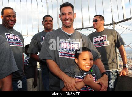 27. Juli 2011 - Manhattan, New York, USA - CC SABATHIA, MIKE HARKEY und FREDDY GARCIA zusehen, wie JORGE POSADA hat einen lachen mit Student Frantz Bleus auf der 86. Etage Sternwarte. New York Yankees-Spieler und Trainer zusammen mit einer Gruppe von haitianischen Kindern aus Ss. Joachim und Anna Schule in Queens (die Flüchtlinge aus dem Erdbeben 2010), "den Schalter umlegen" und Licht der Empi Stockfoto