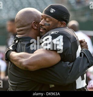 11. August 2011 - Oakland, CA, USA - Oakland Raiders Vs Arizona Cardinals O.co Coliseum Donnerstag, 11. August 2011.  Raiders neuer Cheftrainer Hue Jackson teilt Umarmung mit Sicherheit Michael Huff (24)... Kardinäle Niederlage in Vorsaison Spiel Raiders 24-18. (Kredit-Bild: © Al Golub/ZUMAPRESS.com) Stockfoto
