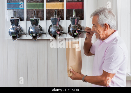 Senior woman Kaffeebohnen im Supermarkt zu kaufen Stockfoto