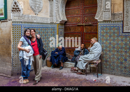 Zwei Touristen posieren für Bilder außerhalb der Moschee Sidi Ahmed Tijani, die Medina, Fes, Marokko Stockfoto