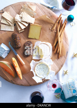 Käseplatte mit Brot und Rock Melone am gedeckten Tisch Stockfoto