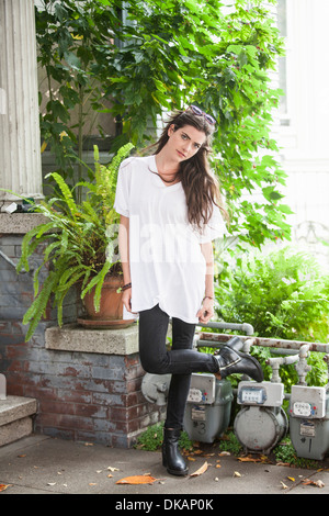 Porträt der jungen Frau auf einem Bein stehend Stockfoto