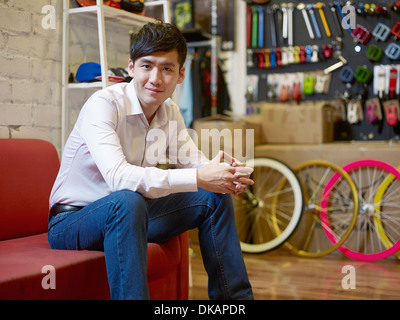 Porträt der junge Mann sitzt im Bike-shop Stockfoto