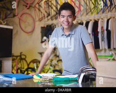 Porträt des jungen Mannes Blick in die Kamera im Bike-shop Stockfoto