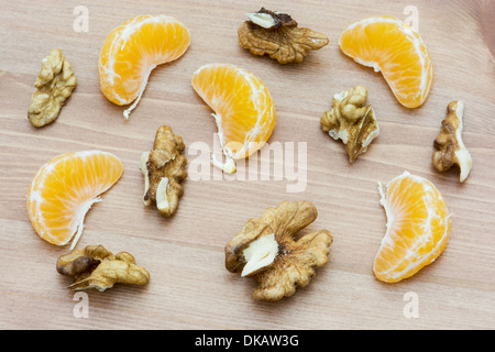 In Scheiben geschnittene Walnüsse und Mandarinen auf dem Holztisch. Stockfoto