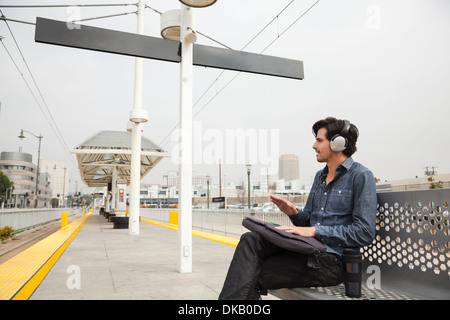 Mann trägt Kopfhörer und Trommeln Hände am Bahnhof, Los Angeles, Kalifornien, USA Stockfoto