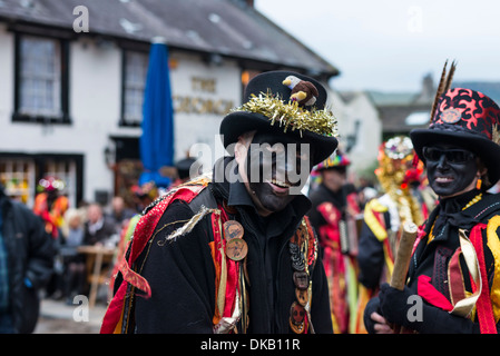 Mann mit bemaltem Gesicht Teil des Morris Dancers in hell farbigen Kostümen Durchführung in Castleton in Derbyshire England Stockfoto