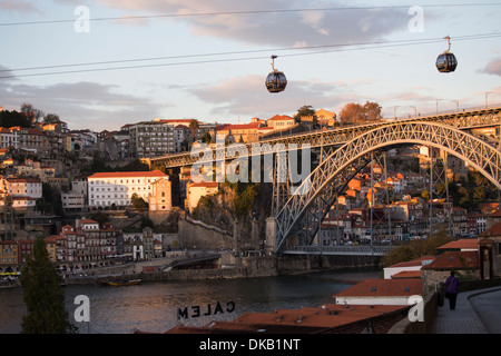 Seilbahnen über Fluss mit Brücke, Porto, Portugal Stockfoto