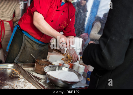 Kochen Sie Prise Löffel Zucker auf Churros an Essen Zähler Derbyshire England Stockfoto