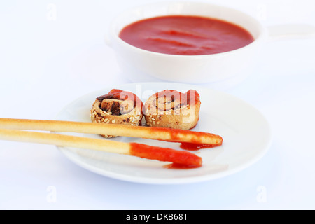 Zwieback mit Sesam, Brot-Sticks und roter Soße auf grauem Hintergrund isoliert. Stockfoto